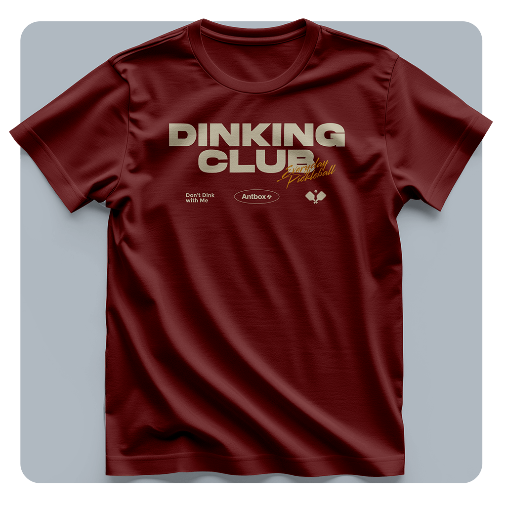 Maroon t-shirt with 'Dinking Club' text on a light gray background